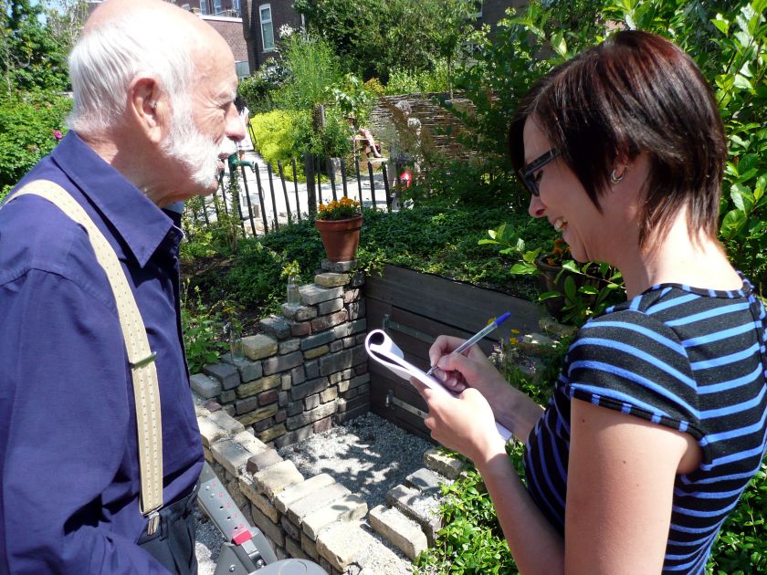 De, met een rollator door de tuin struinende bezoeker, beantwoordt een paar vragen voor de Posthoornjournaliste. Foto door Oenkenstein.